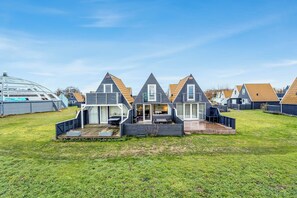 Uma fileira de casas modernas, com dois andares, teto plano e área de varanda coberta.