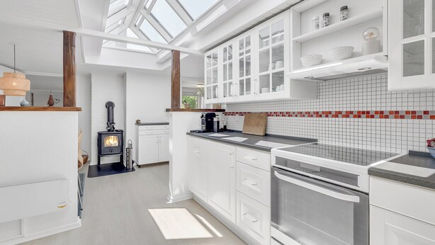 A modern kitchen with white cabinetry, a built-in stove, and a skylight. - Unique holiday home in quiet surroundings (Storvorde)