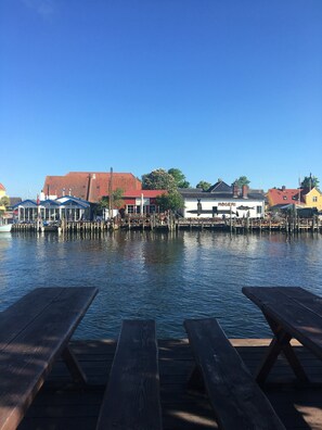 A waterfront view with wooden docks, a marina, and buildings with signage.