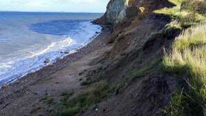 A coastal landscape with a cliff, beach, and ocean. - Cottage on Fur island with exceptional sea view (Fur)
