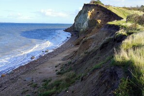 A coastal landscape with a cliff, beach, and ocean. - Cottage on Fur island with exceptional sea view (Fur)