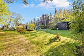 Il s’agit d’une propriété résidentielle dotée d’une pelouse bien entretenue, d’une petite maison et d’un abri de jardin.