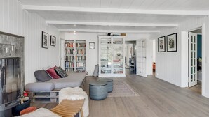 Un salon spacieux doté d’une cheminée, de bibliothèques, d’un canapé et d’une vitrine.