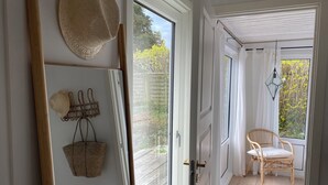 A room with a wooden ladder, a woven basket, and a wicker chair near a door leading outside. - Stunning home in Unknown with 3 Bedrooms and WiFi (Allinge)