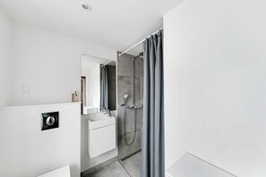 A modern bathroom with a shower, a sink, and a mirror. - Spacious house with sea views from all rooms (Rønne)