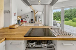 Cocina moderna con una isla grande, horno empotrado y vistas a una terraza.