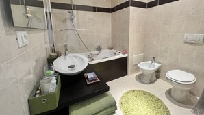 A modern bathroom with a sink, bidet, toilet, and bathtub. - Charming bedroom in luxurious villa with seaview (EZE)