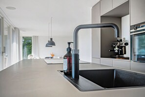 Una cocina moderna con un lavamanos integrado, un grifo y una botella de desinfectante para manos.