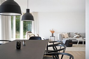 Un salon moderne comprenant une table à manger, des chaises, un canapé et une table basse.