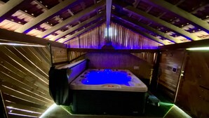 Ein Whirlpool in einem Holzraum mit schrägen Decken und Holzwänden.