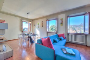 Un salon moderne avec un canapé bleu, une table à manger et des chaises.