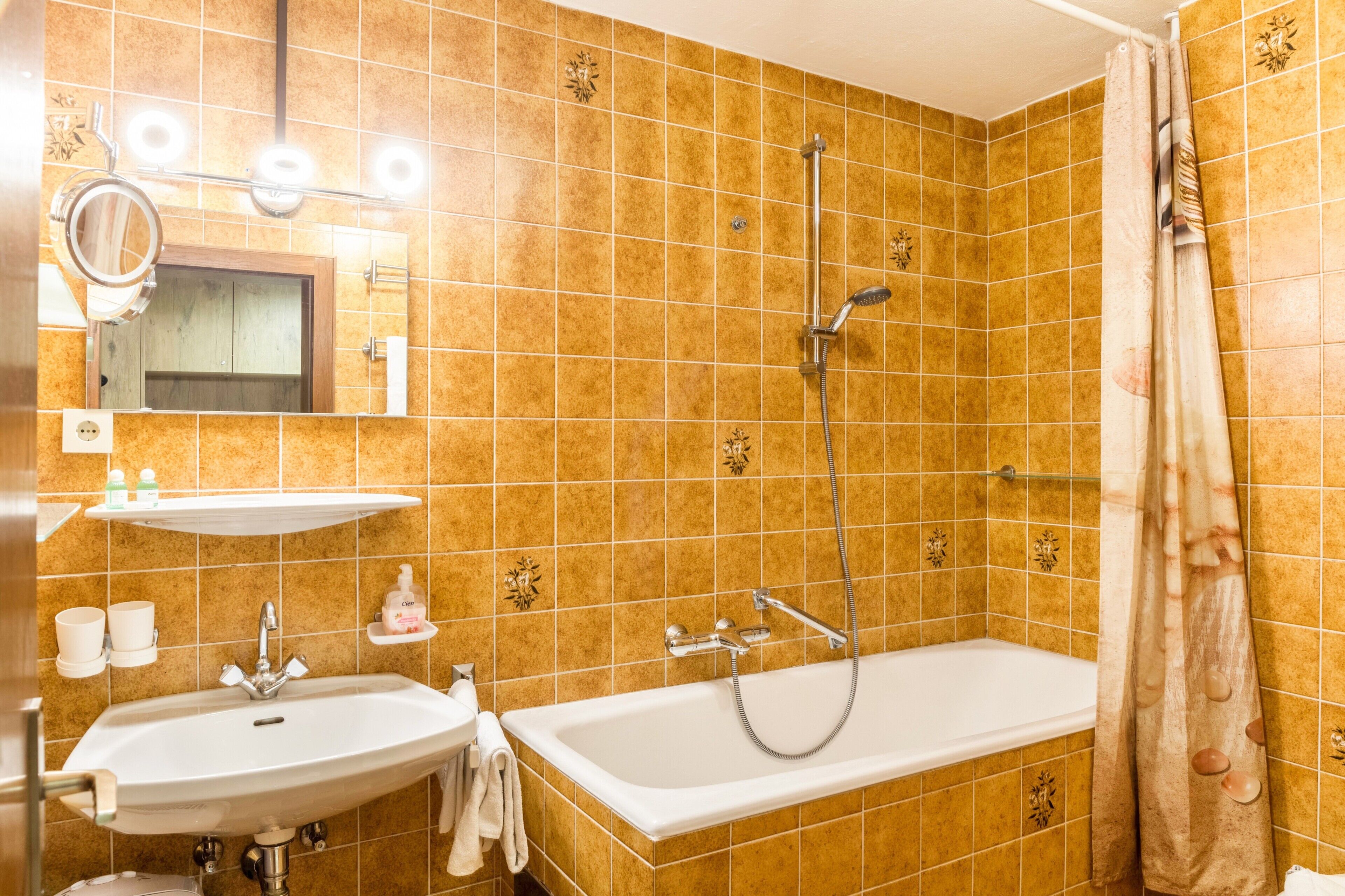 Ein Badezimmer mit Waschbecken, Spiegel, Dusche und Badewanne.