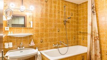 Ein Badezimmer mit Waschbecken, Spiegel, Dusche und Badewanne.