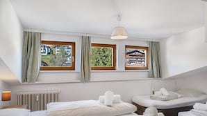 A hotel room with two beds, a window with curtains, a radiator, and a lamp. - Holiday Apartment "Haus Excelsior Top 40" with Mountain View, Balcony & Wi-Fi (Seefeld in Tirol)