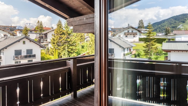 A balcony with a wooden railing, a view of houses, and a mountain in the background. - Holiday Apartment "Haus Excelsior Top 40" with Mountain View, Balcony & Wi-Fi (Seefeld in Tirol)
