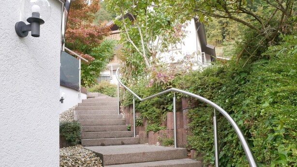 A staircase with metal railings leading to a building with a white exterior wall. - Holiday Apartment "Am Eiberg" with Mountain View, Private Terrace & Wi-Fi (Bad Wildbad)
