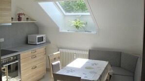 A compact kitchen with a microwave, oven, and a small potted plant on a shelf. - Apartment 'Schelb' with Mountain View, Balcony and Wi-Fi (Sasbachwalden)