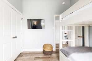 Cozy retreat with a bunk bed, flat-screen TV, and woven basket.