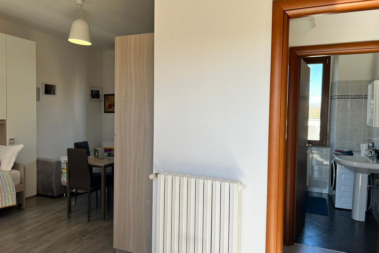 A modern kitchen with a built-in washing machine and a dining area with a table and chairs.