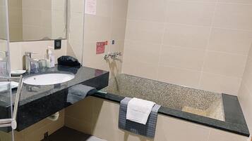 Ein Badezimmer mit Waschbecken, Spiegel, Handtuchhalter und einer Badewanne.
