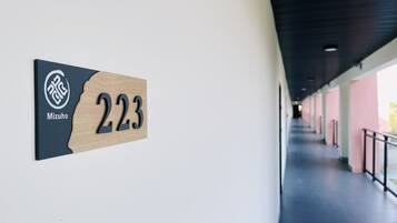Un couloir où est accrochée une plaque en bois indiquant le numéro 223 et le nom « Mizuho ».