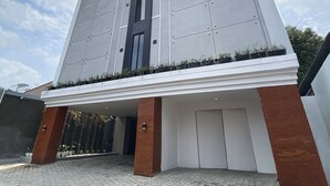 A modern building with a flat roof, large windows, and a sign at the top.