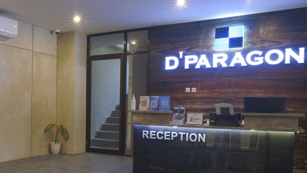 A reception desk with a sign reading "D'PARAGON" and "RECEPTION" in a modern building.