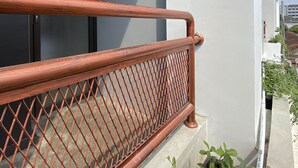 A balcony with a metal railing and a door.