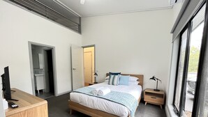 Et moderne soveværelse med en træseng, et skrivebord og et natbord.