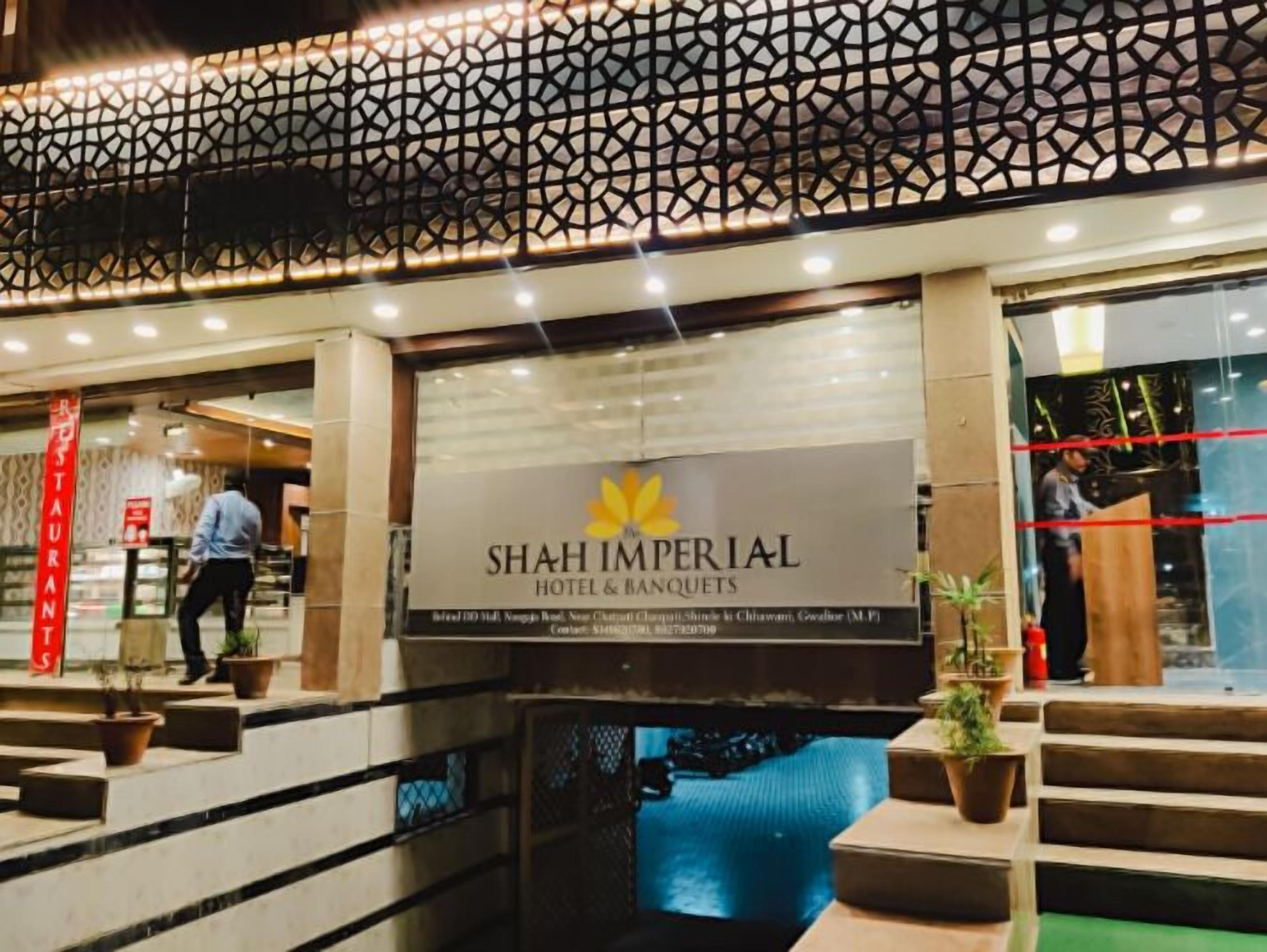 Exterior do Shah Imperial Hotel & Banquets, com fachada decorativa e uma placa.