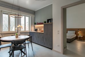 Une cuisine moderne avec un coin repas, un banc intégré et un lit avec une tête de lit.