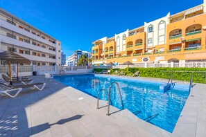 Ein Poolbereich mit Liegestühlen und einer Poolbar.