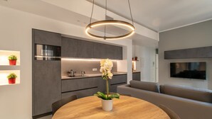 A modern kitchen with a round dining table, built-in appliances, and a minimalist design.