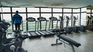 A gym with treadmills, ellipticals, and a bench. - D'Summit Residences by YML Homestay (Johor Bahru)