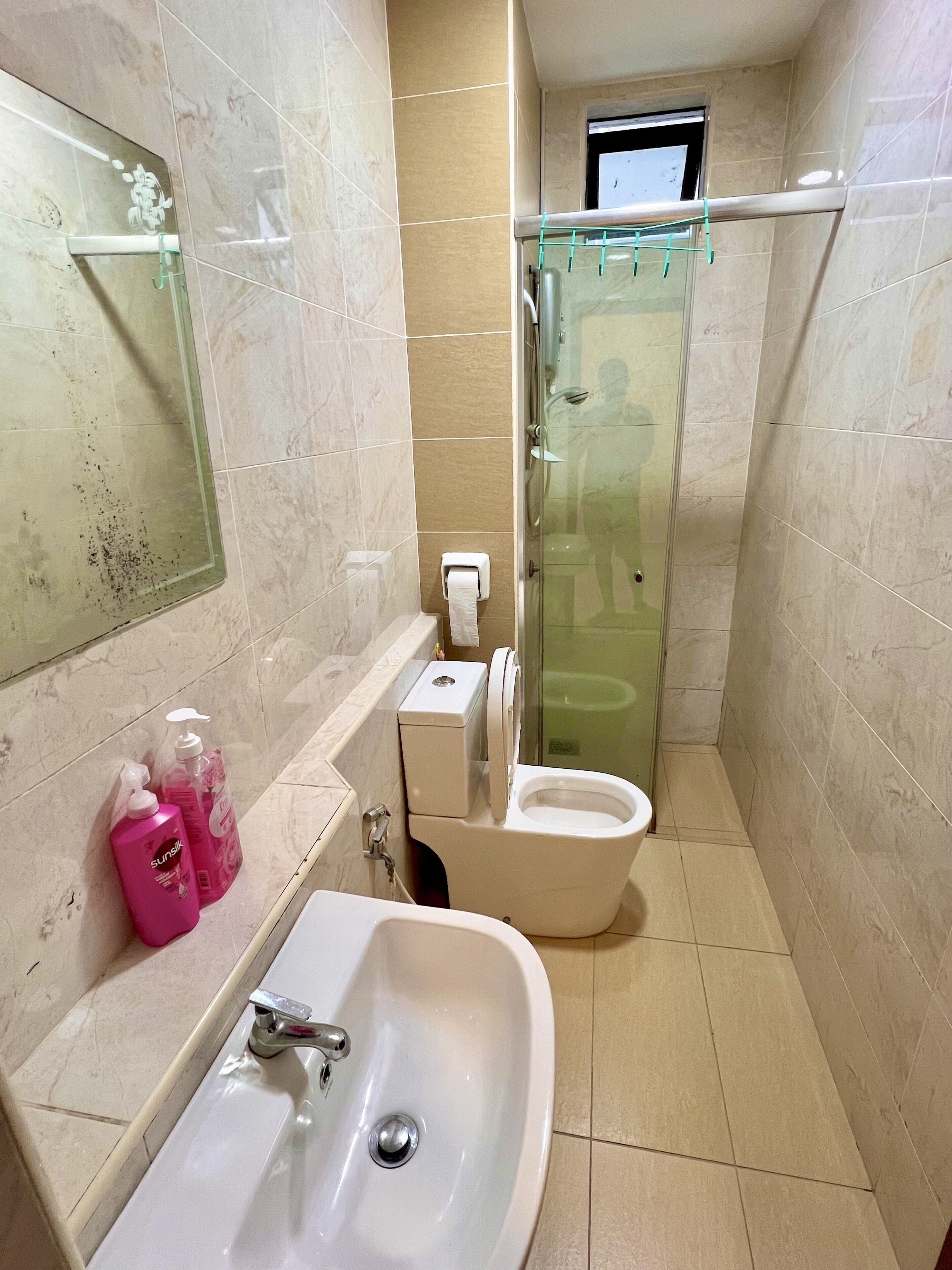 A bathroom with a sink, toilet, and glass shower enclosure.