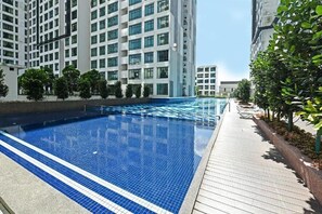 A modern residential building with a swimming pool and a wooden deck. - D'Summit Residences by YML Homestay (Johor Bahru)
