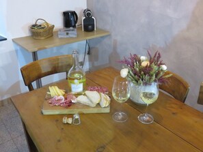 A wooden table with a bottle of wine, glasses, a cheese board, and a bouquet of flowers. - Cozy apartment—nestled amid the natural beauty of the Antrona Valley (Locasca)