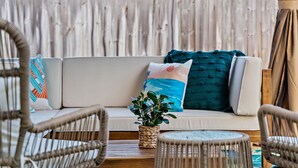 A wicker sofa with cushions, a woven plant pot, and wicker chairs in a sunlit room with a wooden floor. - Clearwater Villa / Heated Pool, Hot Tub, Golf! (Clearwater)