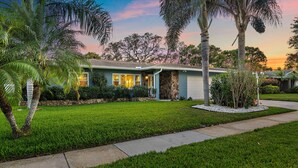 A single-story house with a stone facade, a well-maintained lawn, and a driveway leading to the front door. - Clearwater Villa / Heated Pool, Hot Tub, Golf! (Clearwater)
