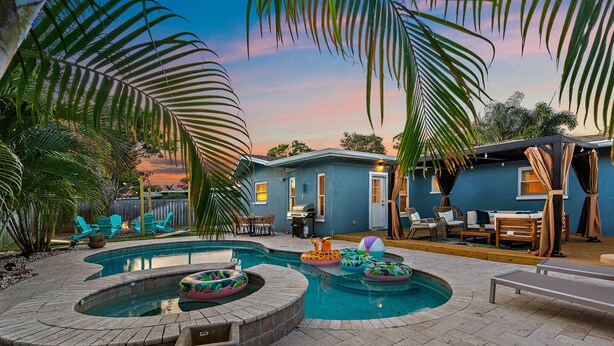 A backyard with a swimming pool, lounge chairs, and a house. - Clearwater Villa / Heated Pool, Hot Tub, Golf! (Clearwater)