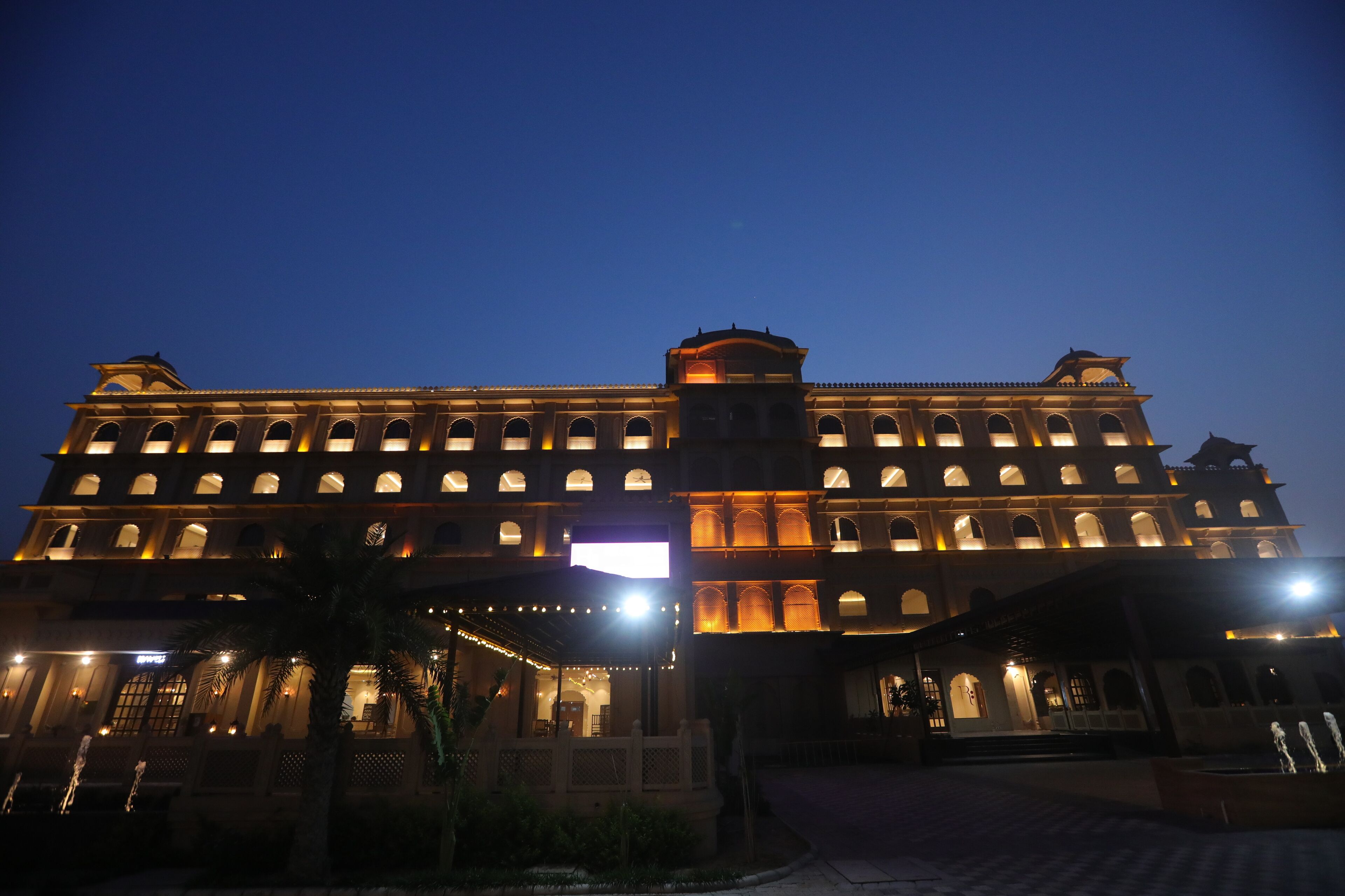 A large, multi-story hotel with illuminated windows and a central tower.