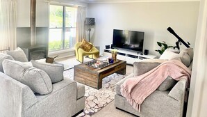 Uma sala de estar com lareira, TV e assentos confortáveis.