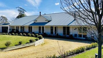 A two-story house with a covered porch, a gravel driveway, and a well-maintained lawn.