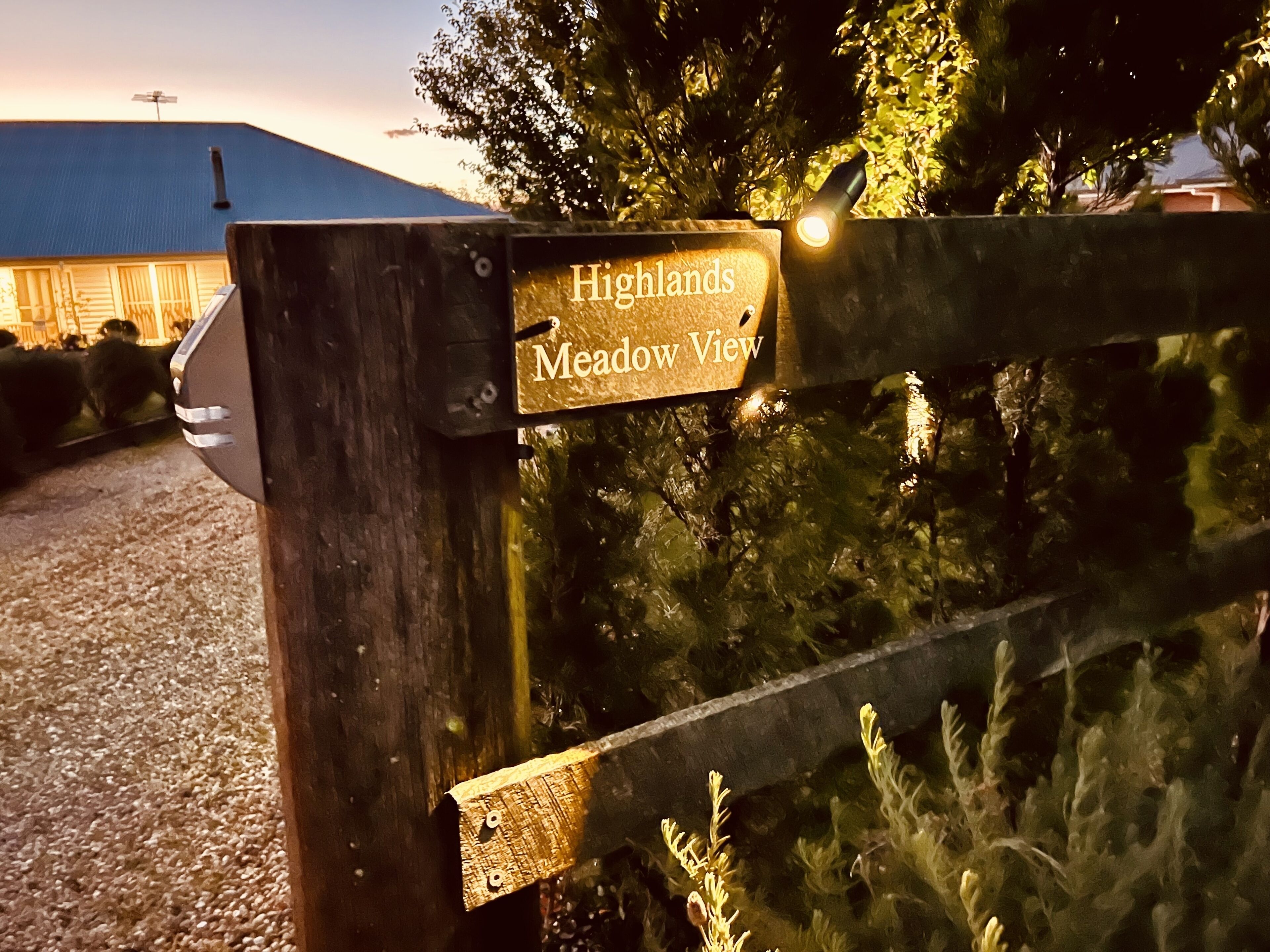 A wooden sign with the text "Highlands Meadow View" attached to a fence.