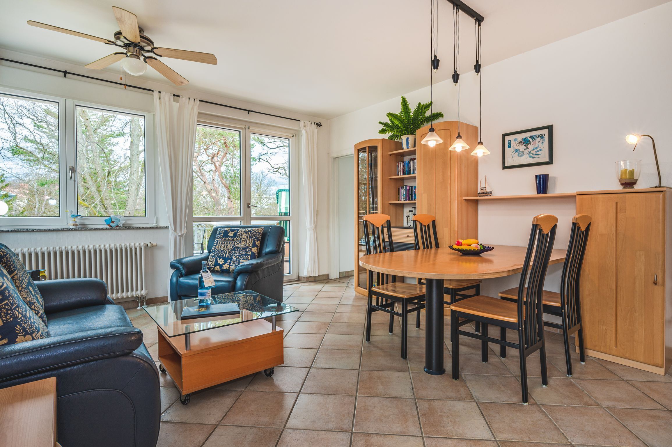 Un salon moderne comprenant un canapé, une table basse et un coin repas avec des chaises et une table.