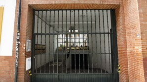 A large metal gate with a number 101 sign above it, leading to a building with a brick facade. - Rentalsevilla Escapada en San Luis (Sevilla)