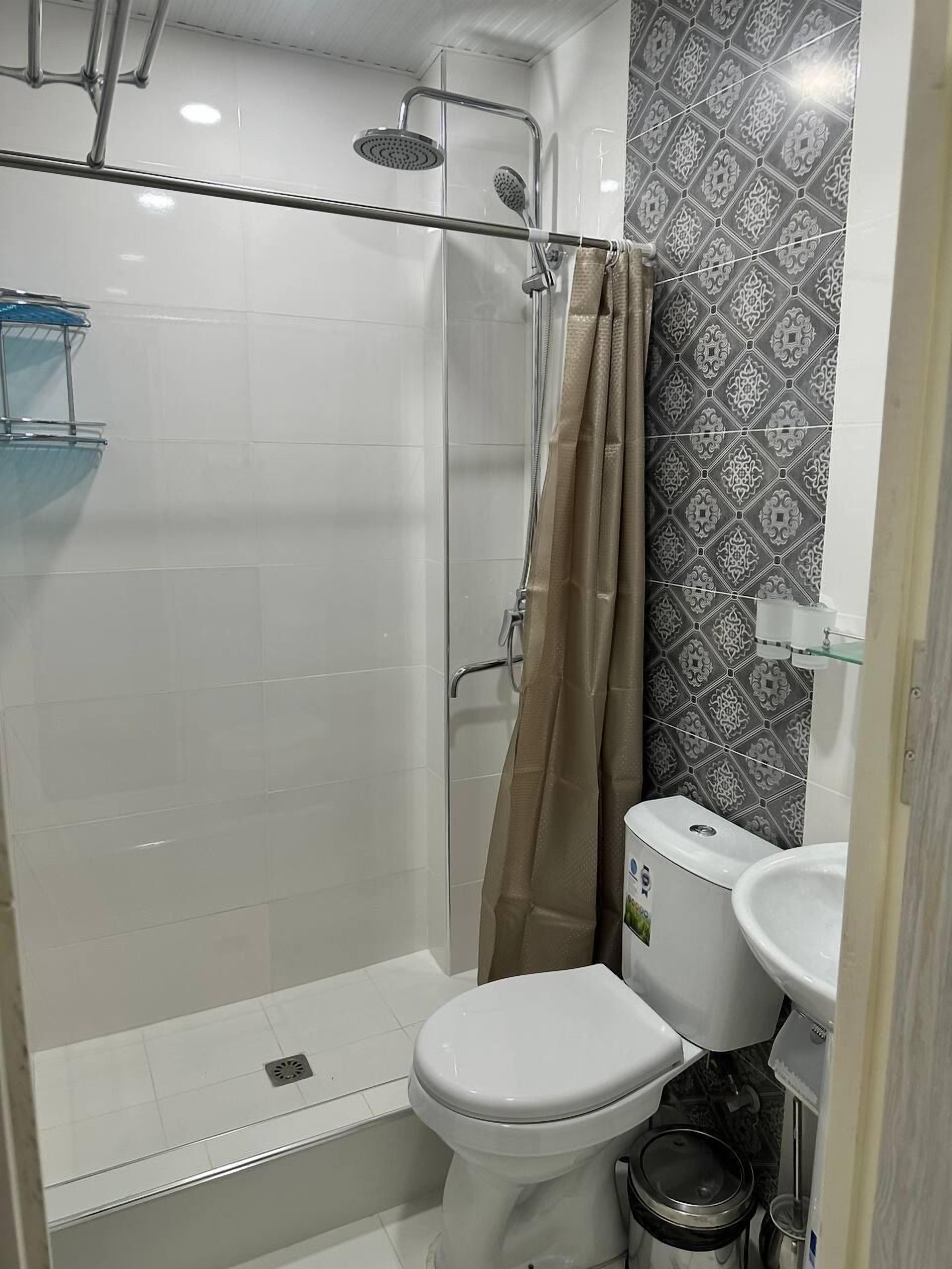Ein Badezimmer mit Dusche, Toilette und Waschbecken.