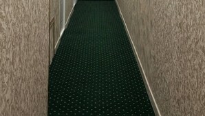 A narrow hallway with patterned walls and a carpeted floor, leading to a staircase. - Semurg Hotel (Tashkent)