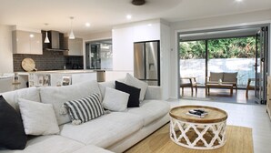 Un salon moderne avec un canapé, une table basse et une cuisine en arri ère-plan.