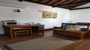 A room with a wooden desk, a bed with a headboard, a wall-mounted air conditioner, and a painting. - Oxen Car House 1 Bedroom (Capelo)